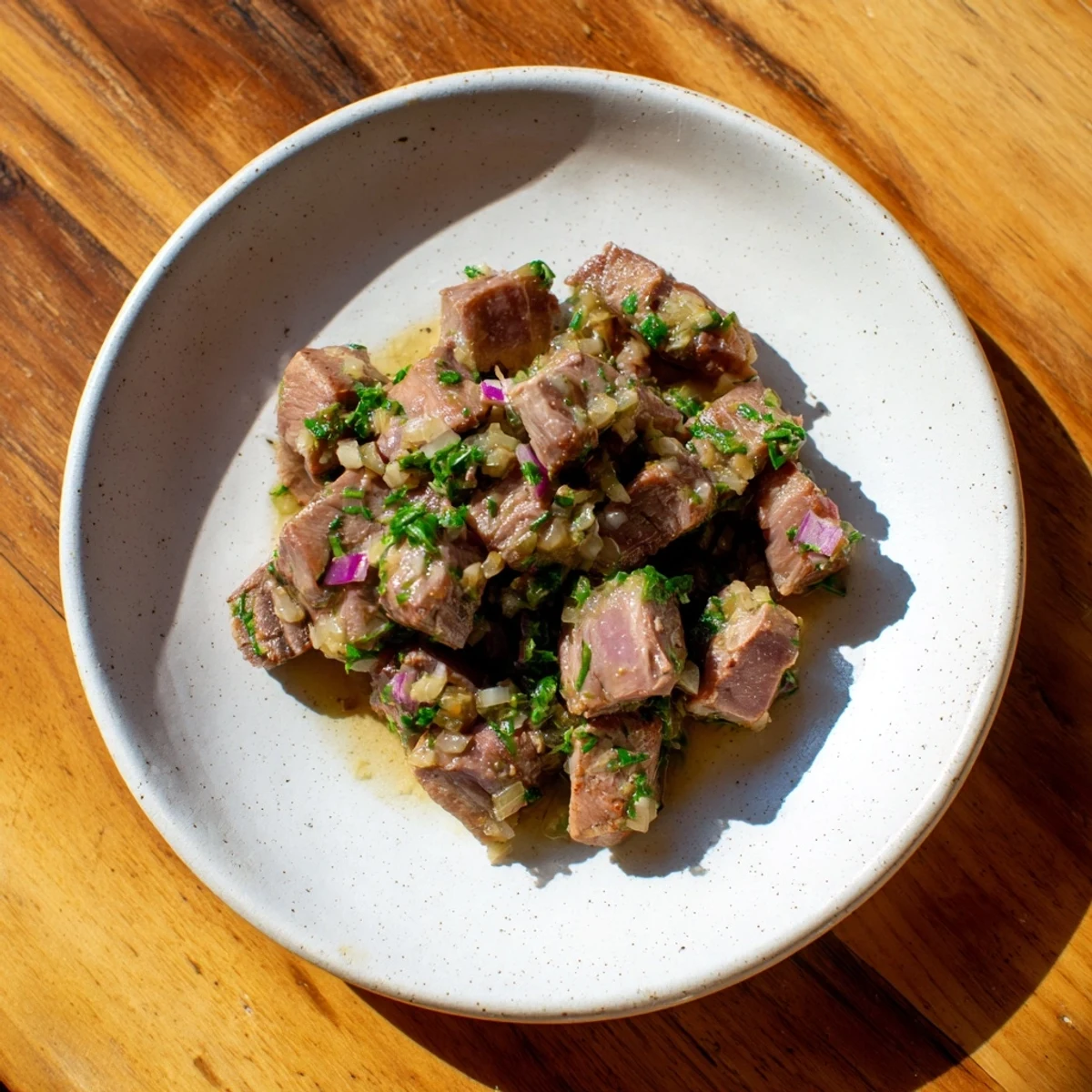 Sizzling skillet-seared steak bites glistening with rich, fragrant garlic butter, ready to serve.