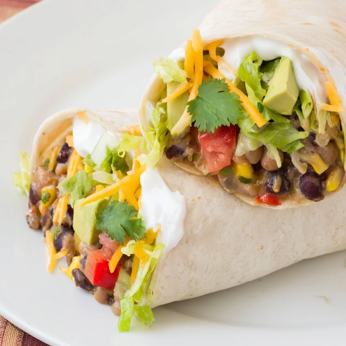A close-up of a delicious and hearty Smoky Black Bean Burrito, wrapped tightly and ready to eat.