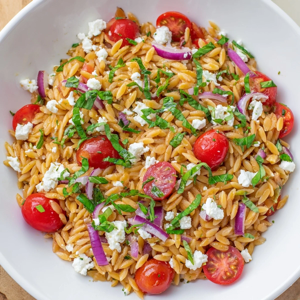 A close-up shot of the fresh Tomato Feta Orzo, showcasing the vibrant herbs and delicious dressing.