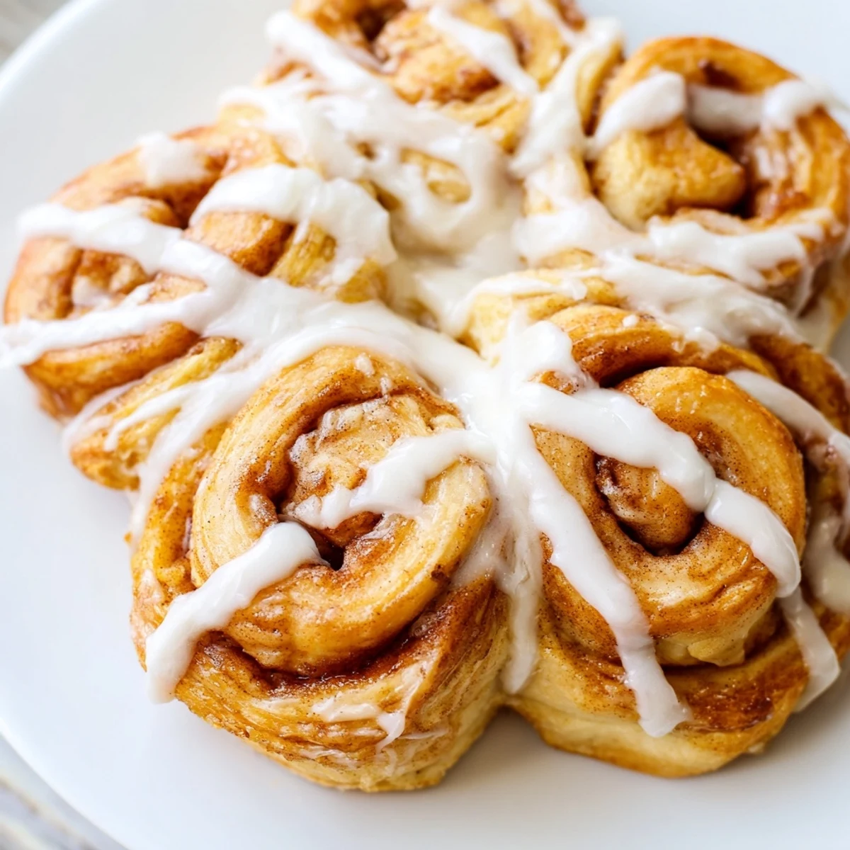 Sweet vanilla-glazed Cinnamon Roll Pull-Apart Snowflake, a festive American dessert, shaped and ready to devour.