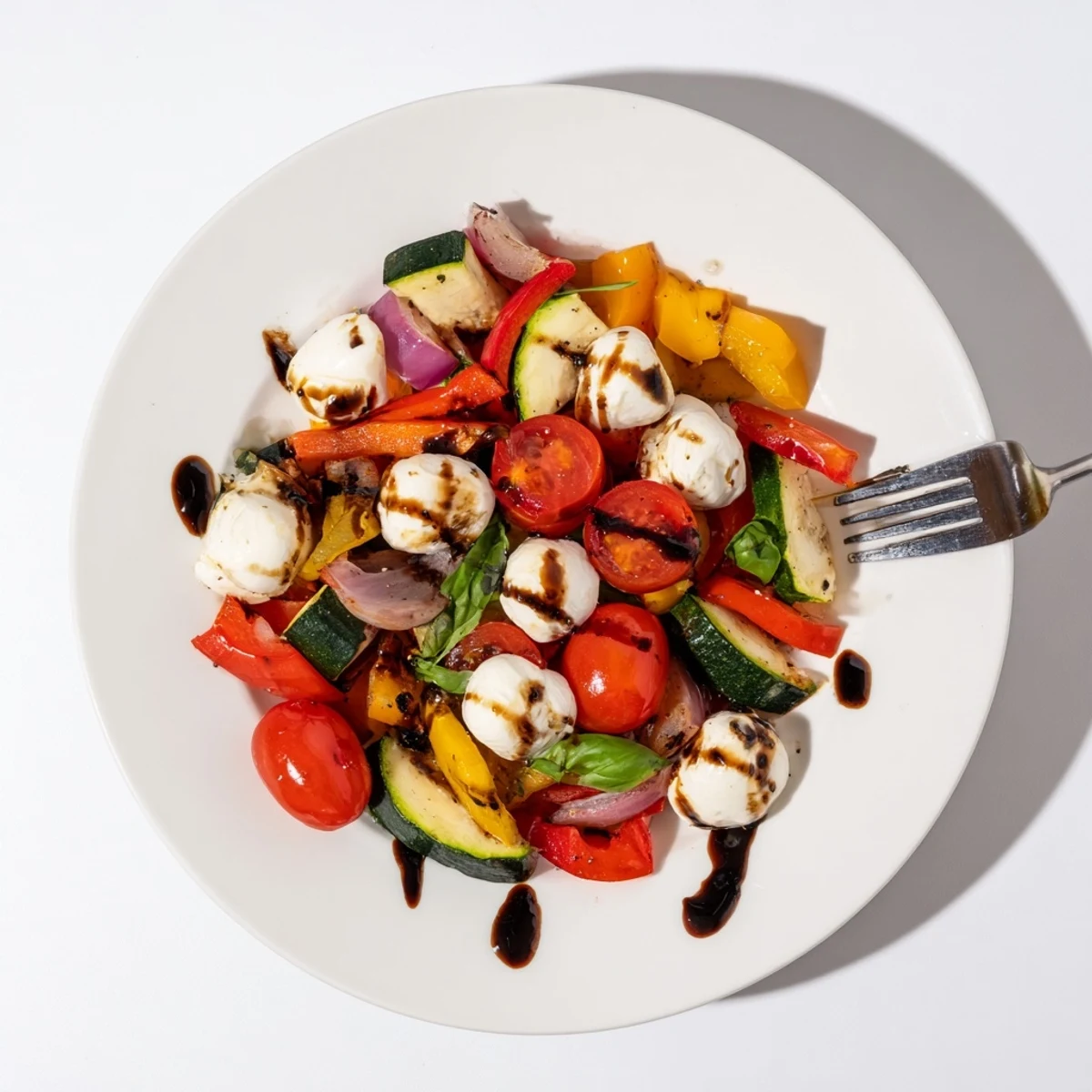 Golden roasted zucchini, bell peppers, and red onion mingle with creamy mozzarella pearls in this vibrant Roasted Veggie Caprese Salad, finished with a sweet balsamic drizzle.  