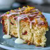 A close-up slice of Heavenly Blood Orange Yogurt Cake reveals fluffy texture, studded with zest and served beside a blood orange.