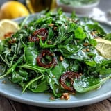 Bright lemon vinaigrette arugula salad with shaved Parmesan, toasted pine nuts, and vibrant greens – a fresh, tangy Italian-inspired starter.