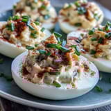 Classic deviled eggs topped with smoky paprika and fresh chives, a tangy and elegant finger food.  