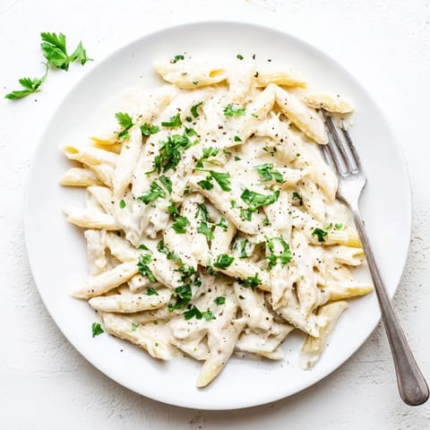 A skillet of Creamy Milk Pasta One-Pot, with golden Parmesan melted into the velvety sauce, garnished with fresh parsley.