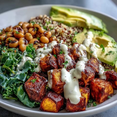 Vibrant Black-Eyed Pea Buddha Bowl filled with roasted sweet potatoes, fresh avocado, and creamy tahini dressing on a bed of quinoa.