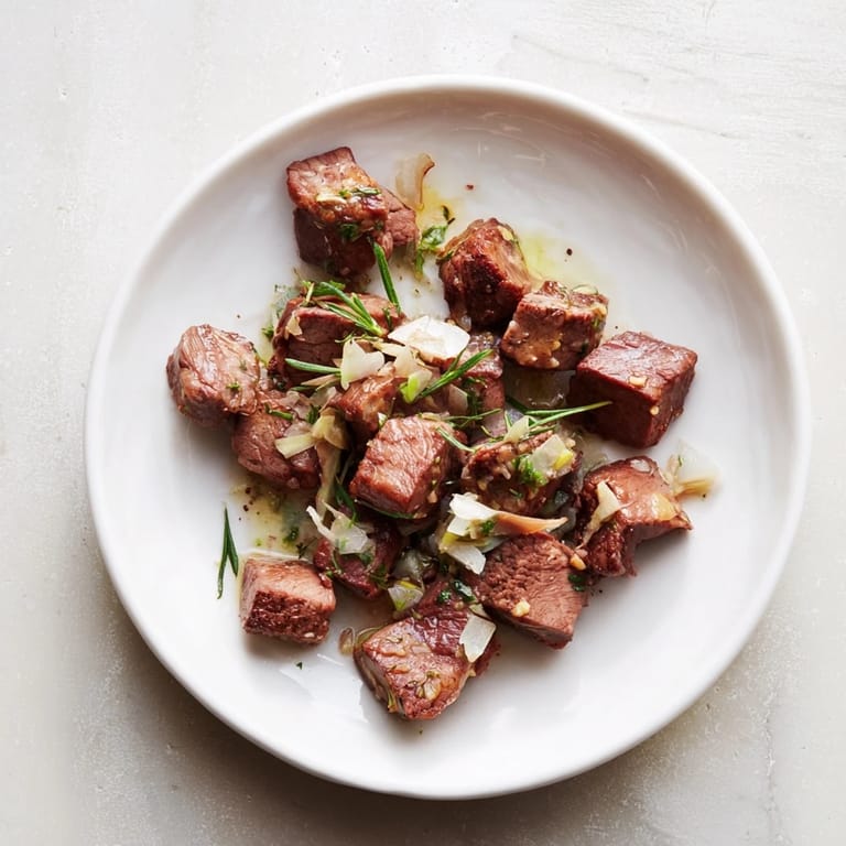 Golden-brown skillet-seared steak bites, tossed in garlic butter, a flavorful main course.