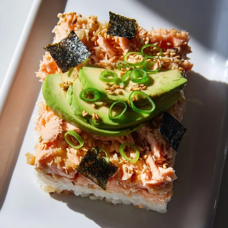 A delicious, cheesy sushi bake casserole with flaky salmon is served with dipping sauce.