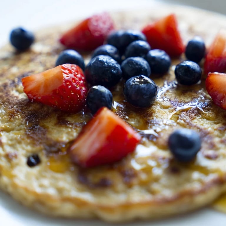 Warm brown banana pancakes sizzling in a skillet, showcasing their fluffy texture and caramelized edges for an easy brunch recipe.