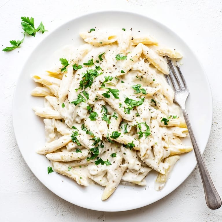 A skillet of Creamy Milk Pasta One-Pot, with golden Parmesan melted into the velvety sauce, garnished with fresh parsley.