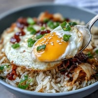 Vibrant Kimchi Cabbage Fried Rice topped with a sunny-side-up egg.